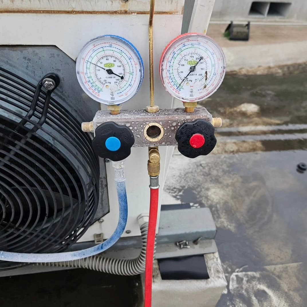 Punjenje freona rashladne jedinice sa manometrima. Precizna kontrola pritiska za optimalan rad sistema.