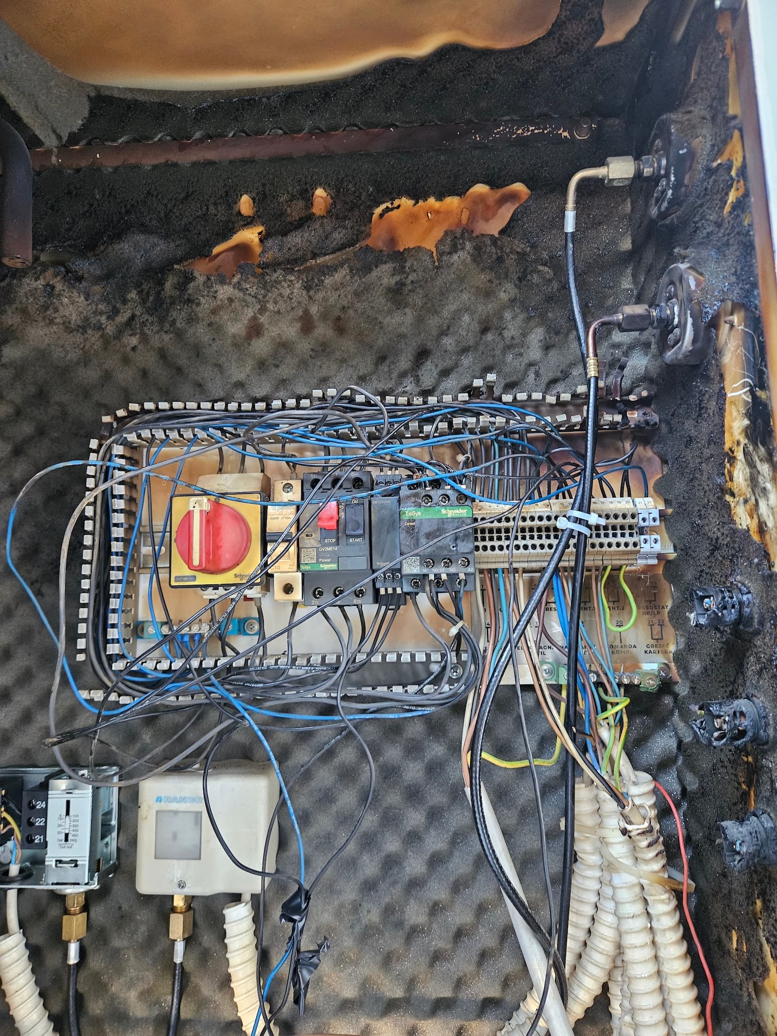 Štete od pregrejavanja na elektro tabli pre remonta. Vidljivo karbonizovana izolacija, istopljena ožičenja i naslage čađi, neophodna kompletna zamena.