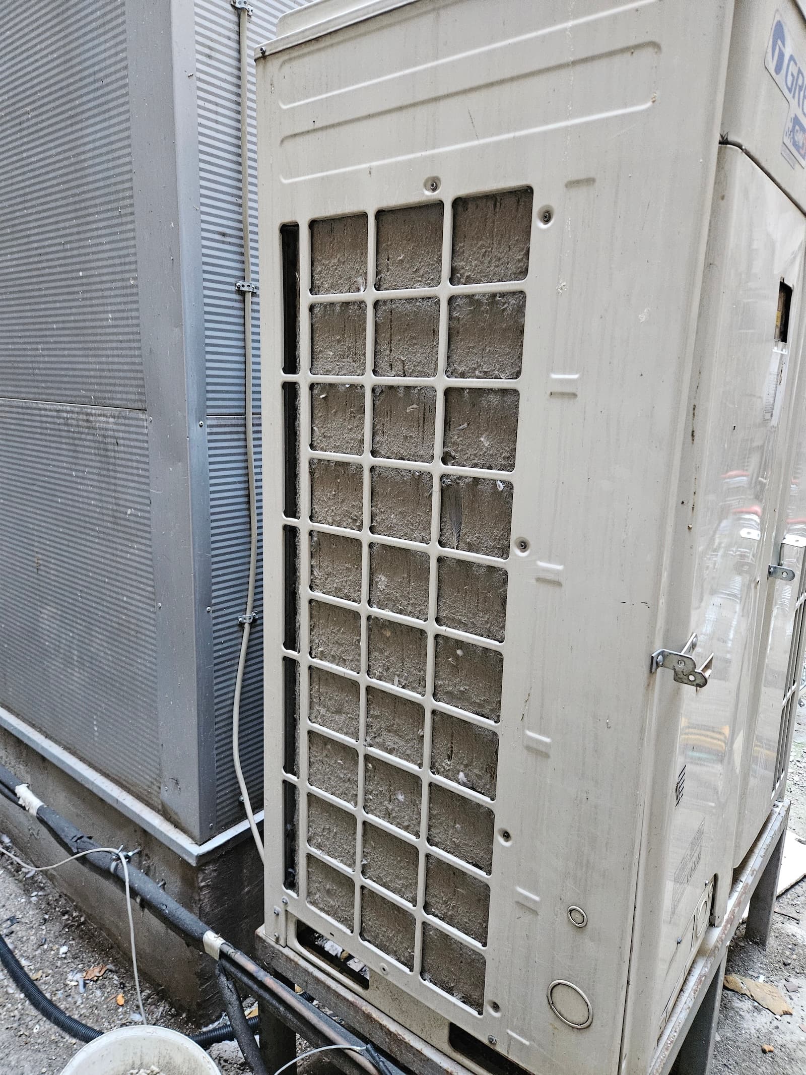 Spoljna jedinica klime sa filterom zaprljanim prašinom. Čišćenje spoljne jedinice je ključno za efikasan rad sistema.