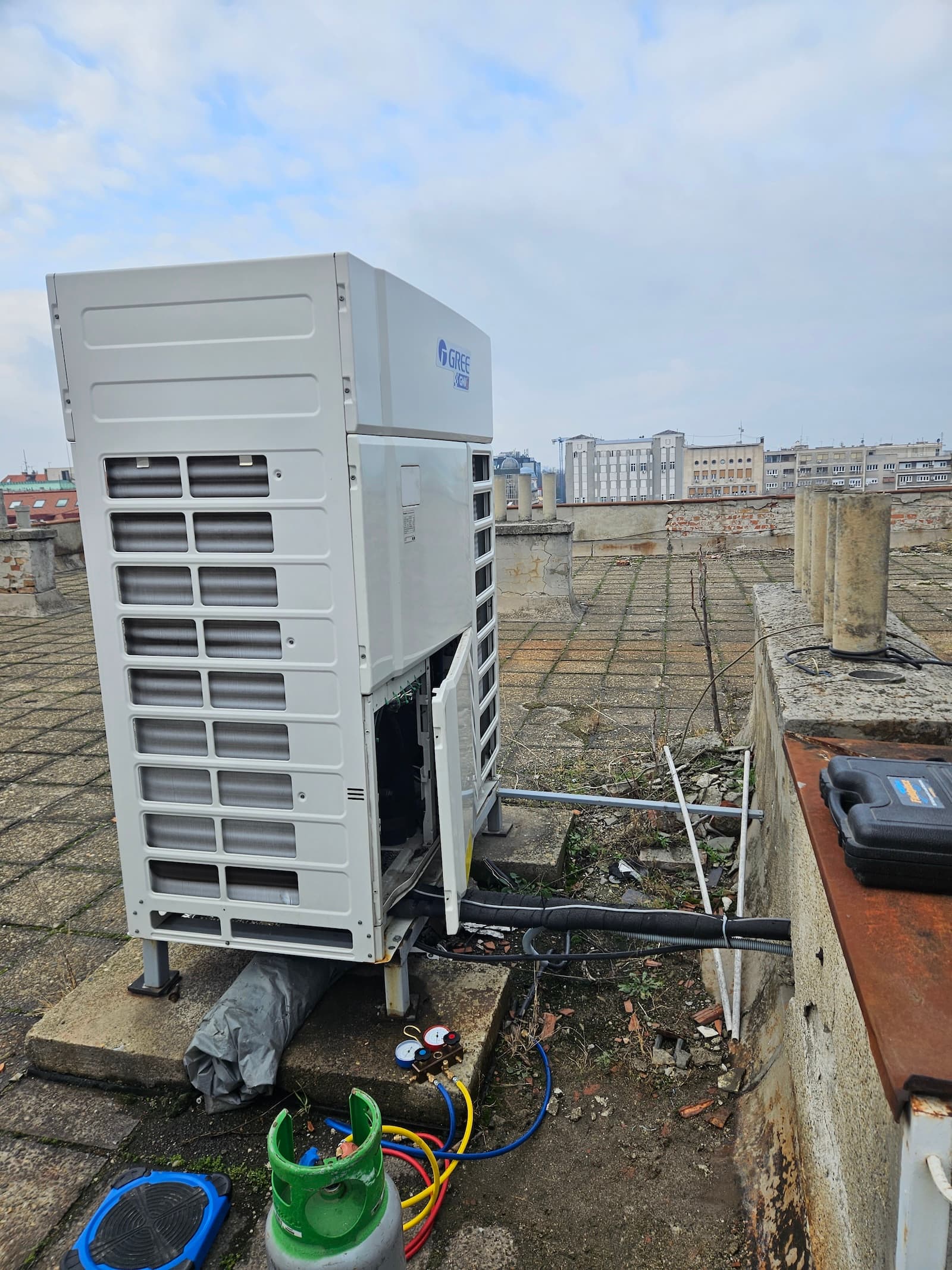 Punjenje freona VRF spoljne jedinice na krovu. Servis velikih komercijalnih sistema zahteva stručnost i specijalizovanu opremu.