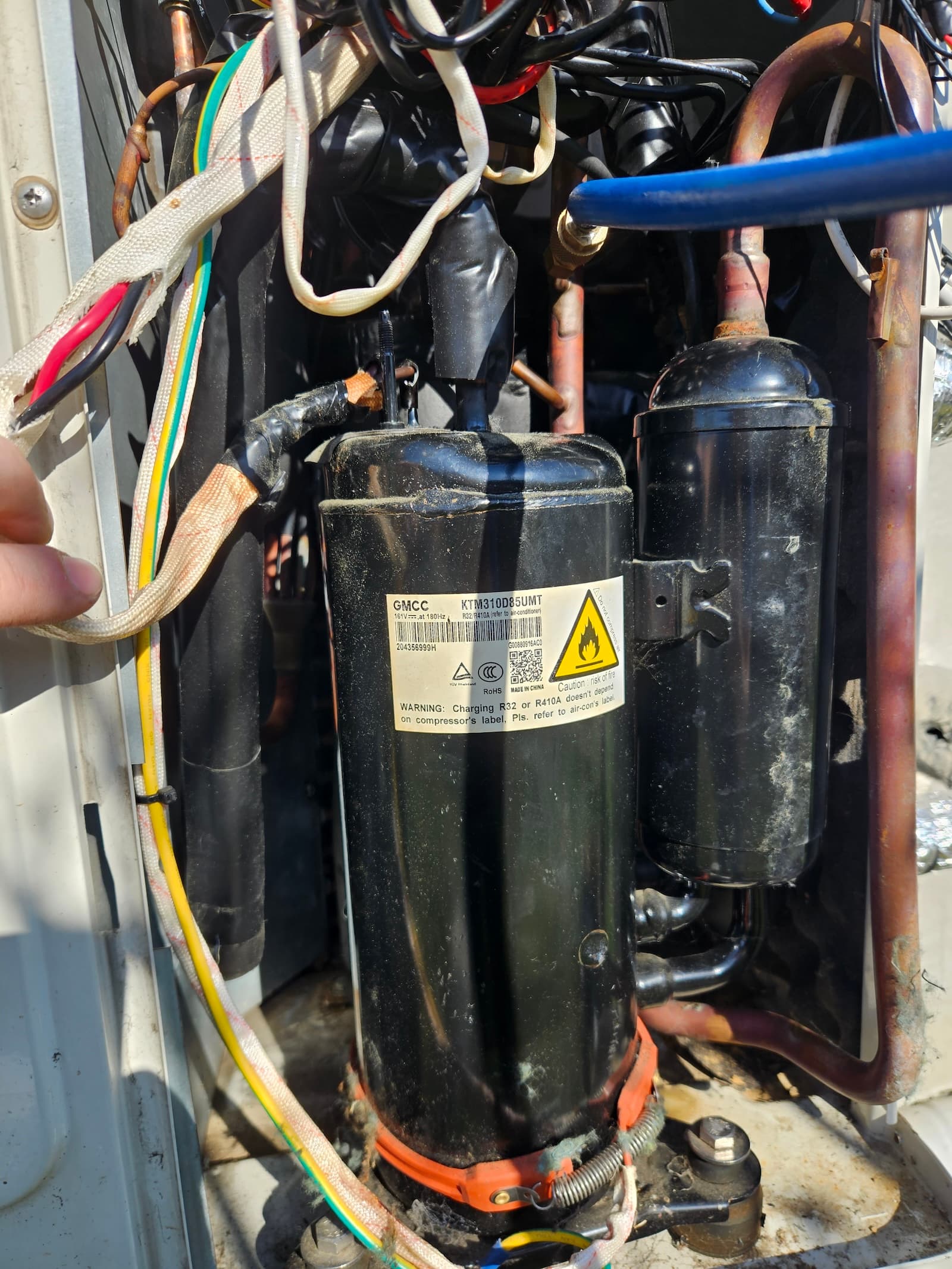 Krupni plan kompresora klime tokom zamene. Remont kompresora je složena intervencija koja zahteva stručno znanje.