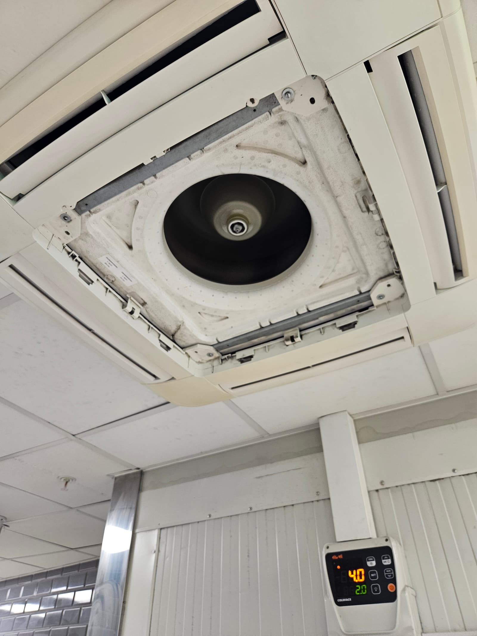 Servis kasetne klime u komercijalnom prostoru. Otvorena unutrašnja jedinica sa pristupom ventilatoru i filterima.