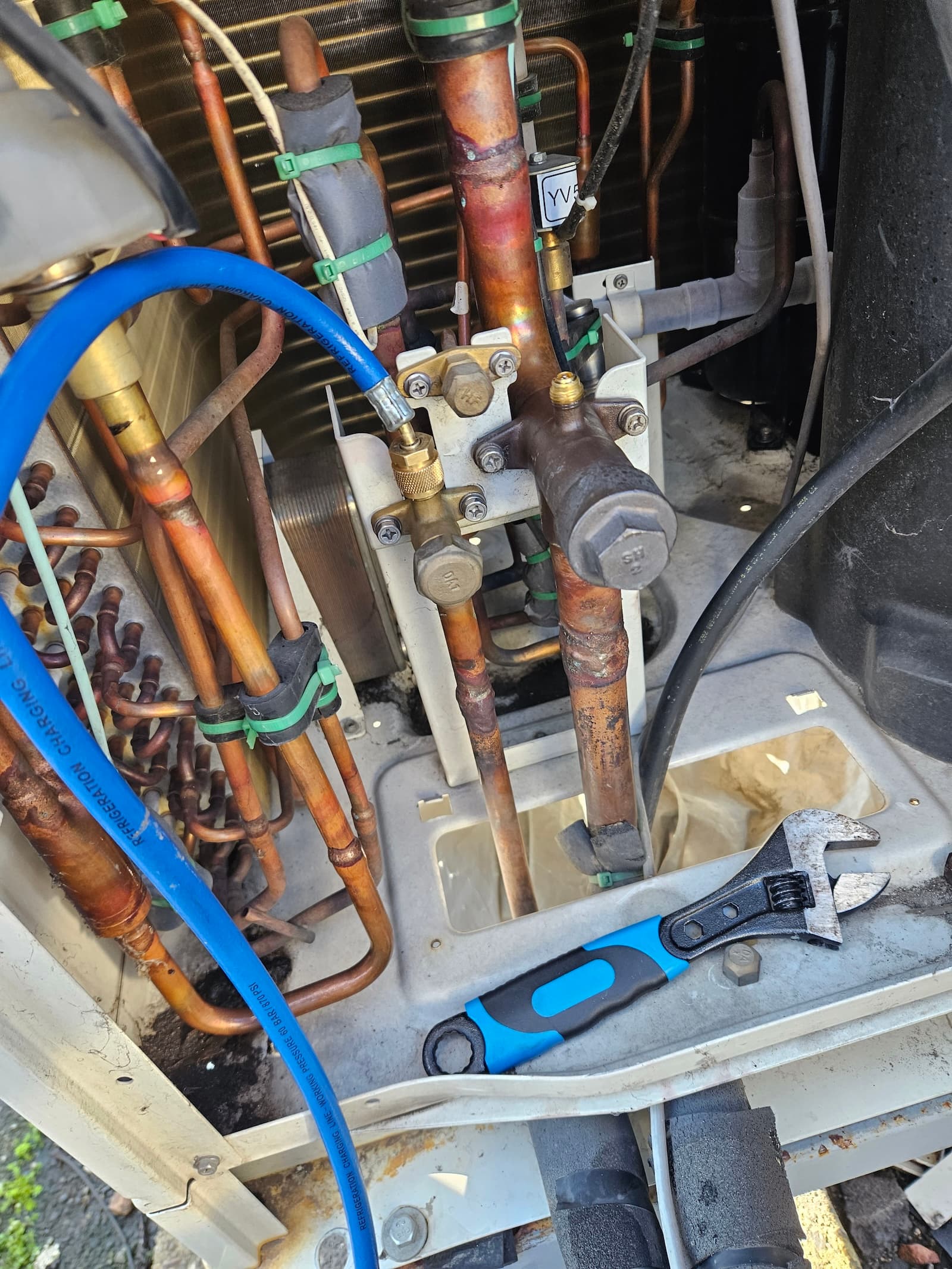 Bakarne cevi i alat pored spoljne jedinice klime. Profesionalni alat za preciznu ugradnju i servis.