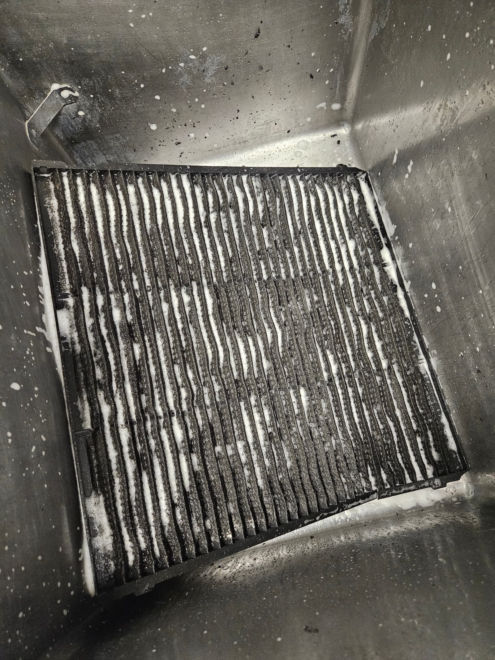 Pranje prljavaog filtera klime u sudoperi. Ručno čišćenje i dezinfekcija svakog filtera za optimalan protok vazduha.